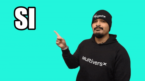 a man wearing a beanie and a multivers sweatshirt pointing