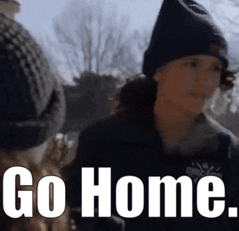 a woman wearing a black hat and a jacket says go home