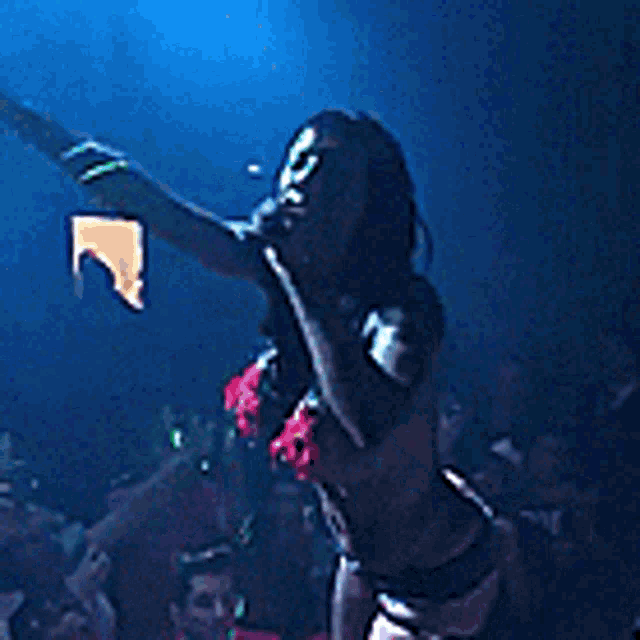 a woman in a bikini is singing into a microphone