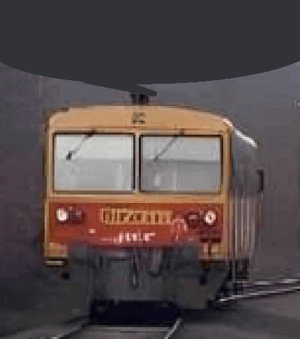 a red and yellow train is going down train tracks .