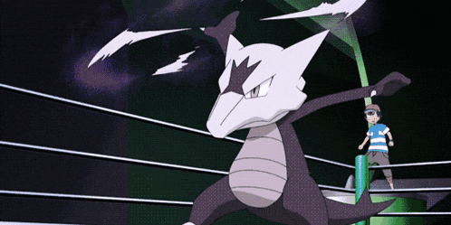 a boy in a blue shirt stands in a ring with a pokemon in the background