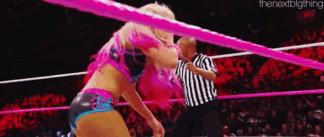 a woman is wrestling a referee in a ring .