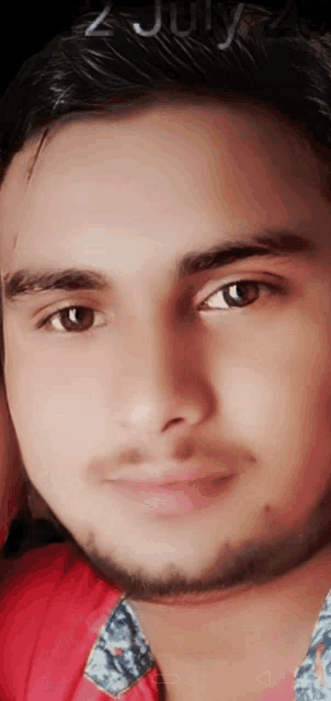 a close up of a man 's face with the word july written on it