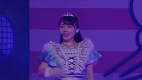 a girl with a tiara on her head is wearing a blue and white dress with the number xxx on the front
