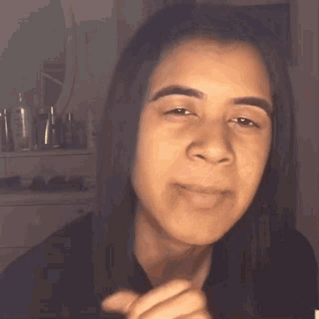 a woman with long hair is making a funny face with her eyes closed