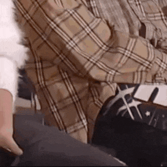 a man in a plaid shirt is sitting on a chair with a woman .