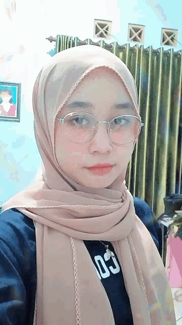 a woman wearing glasses and a scarf with the number 03 on her shirt