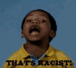 a young boy wearing a yellow shirt that says " that 's racist "