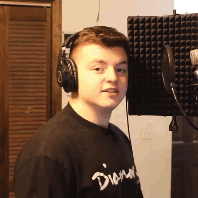 a young man wearing headphones and a black shirt with the word diamond on it