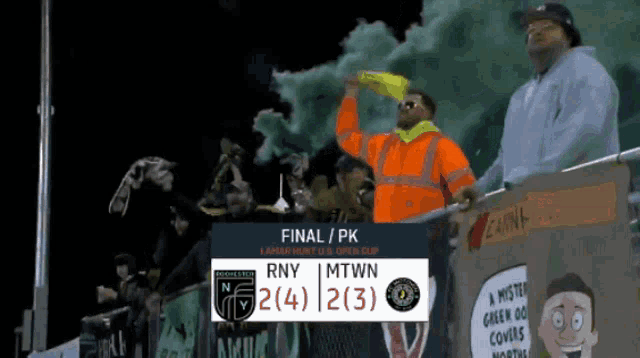 a man in an orange jacket stands in front of a sign that says final pk