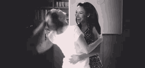 a man and a woman are hugging each other in a black and white photo .