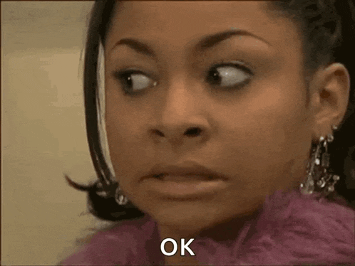 a woman in a pink coat is making a funny face and saying ok .