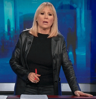 a woman in a black leather jacket is standing in front of a screen that says ' petra ' on it