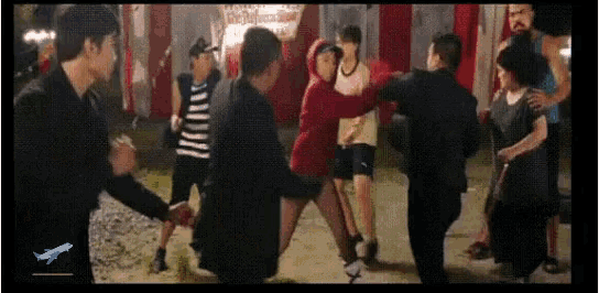 a group of people are dancing in a circle with an airplane in the lower right corner