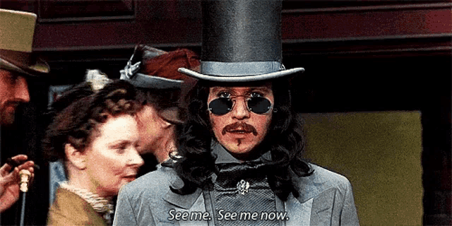 a man wearing a top hat and sunglasses says seems see me now .