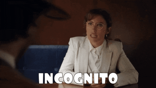 a woman in a white suit is sitting at a table with the word incognito written above her