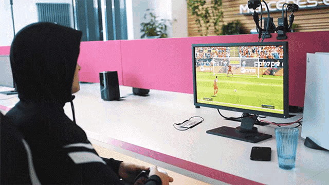 a man in a hoodie is playing a video game on a dell monitor