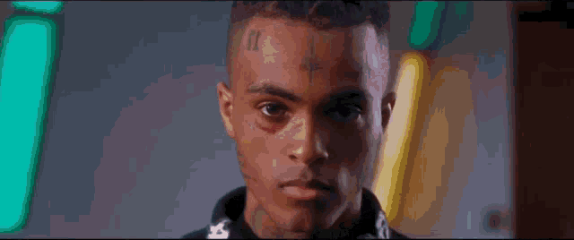 a close up of a man with a tattoo on his face