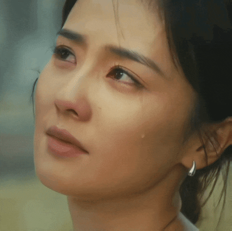 a close up of a woman 's face with a tear running down her face