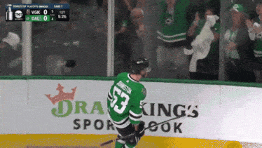 a hockey player in a green jersey with the number 53 on it