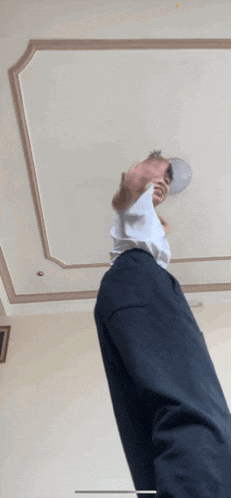 a man wearing a white shirt and black pants is standing in a room