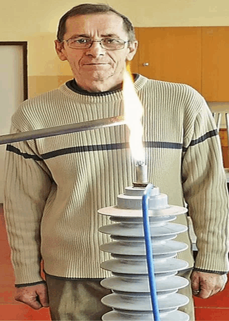 a man in a sweater is holding a torch and a candle