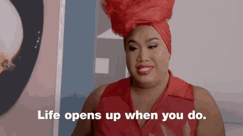 a woman wearing a red shirt and a red turban says life opens up when you do