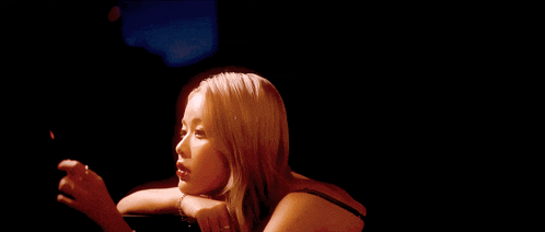 a woman with blonde hair is holding a candle in her hand