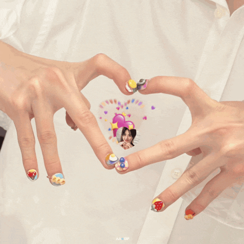 a couple of hands making a heart shape with a picture of a girl on it