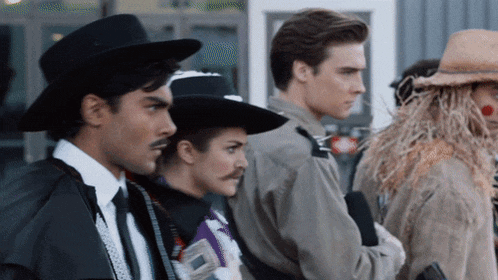 a group of people dressed in costumes including a scarecrow and a cowboy