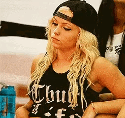 a blonde woman wearing a black tank top that says thug on it