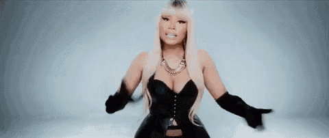 a woman in a black corset and black gloves is standing in front of a blue background .