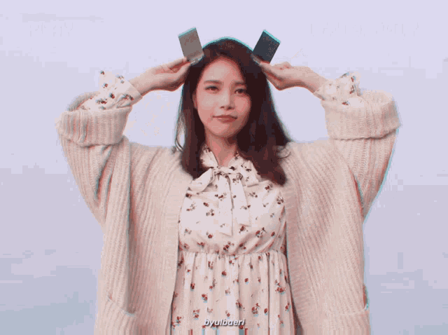 a woman wearing a sweater and a floral dress has the word byulbaerr written below her