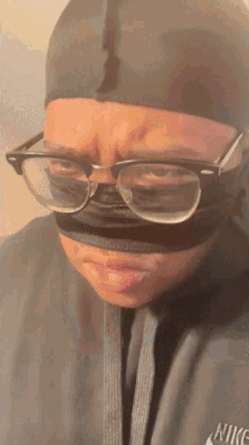 a person wearing glasses and a nike hoodie