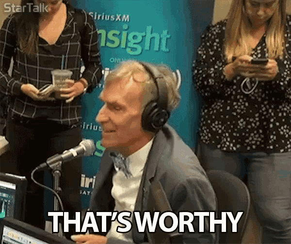 a man wearing headphones says that 's worthy while sitting in front of a microphone