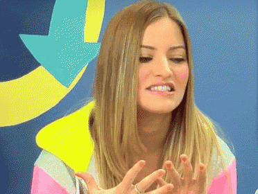 a woman with long blonde hair is making a funny face with her hands in the air .