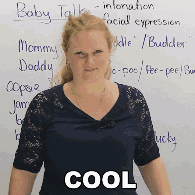 a woman stands in front of a white board with the words baby talk written on it