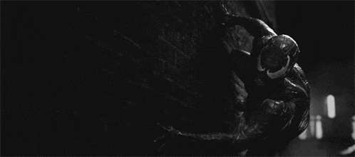 a black and white photo of a spider-man in a venom suit .