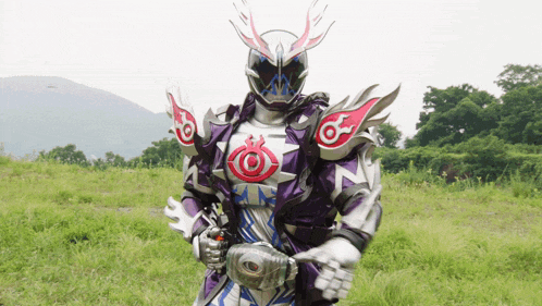 a man in a purple and white costume is standing in a field with a mountain in the background
