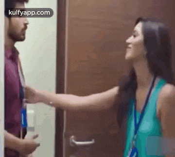 a man and a woman are standing in front of a door .