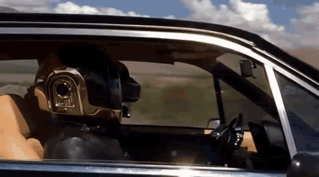 a man wearing a helmet that says ' daft punk ' on it sits in a car