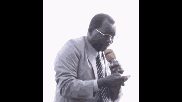 a man in a suit and tie holds an orange microphone