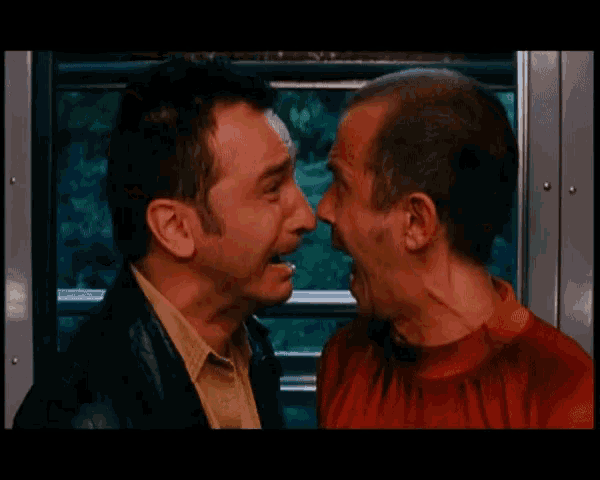 a man in a red shirt is standing next to another man