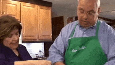 a man and a woman are preparing food in a kitchen .
