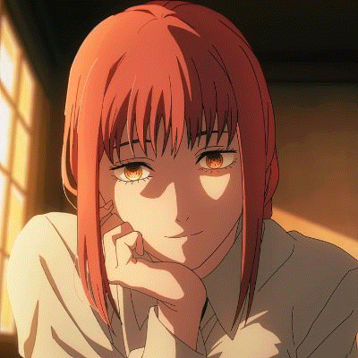 a close up of a girl with red hair and brown eyes sitting in front of a window .