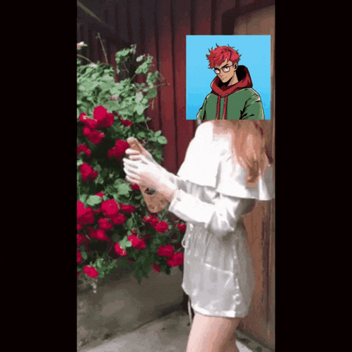 a girl is standing in front of a bush of red roses with a picture of a boy in the background