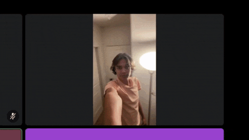 a man taking a selfie in front of a lamp in a dark room