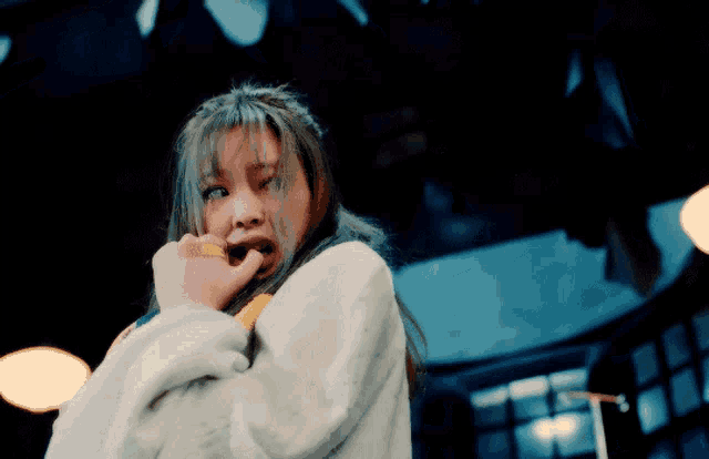a woman in a white sweater is making a face