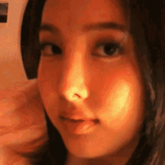 a close up of a woman 's face with a light shining on her nose