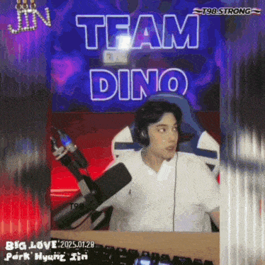 a man wearing headphones sits in front of a microphone with the words team dino behind him